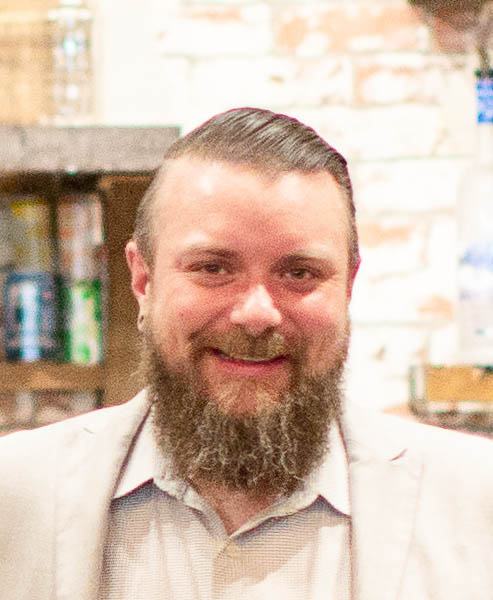 Lloyd Woods smiling wearing a light colored suit.